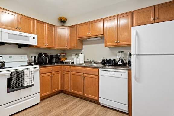 A kitchen with wooden cabinets and white appliances.