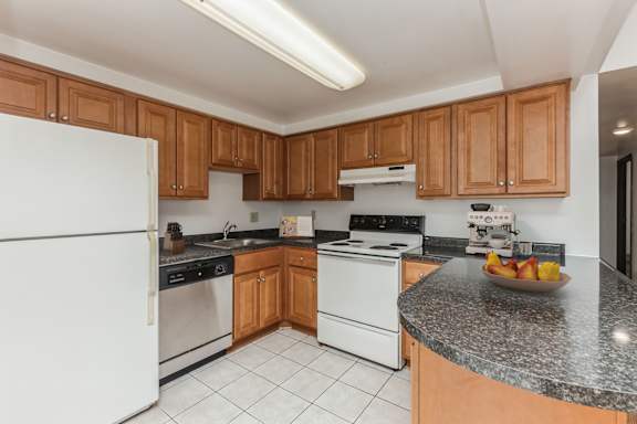a kitchen with white appliances and granite counter tops