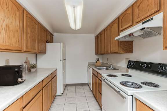 a kitchen with white appliances and wooden cabinets