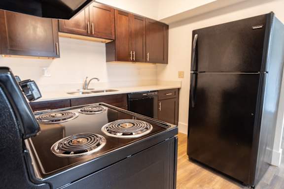 a kitchen with black appliances and brown cabinets