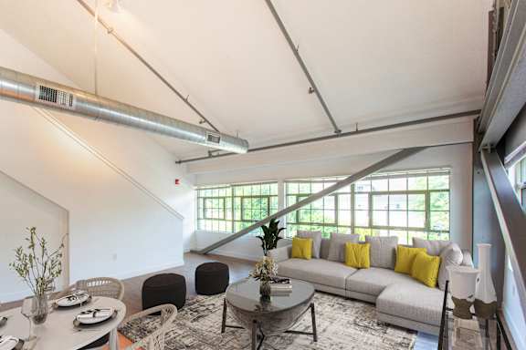 a living room with a gray couch and a coffee table at Ames Shovel Works Apartments, Massachusetts, 02356