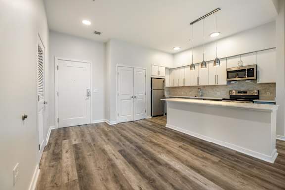 A kitchen area with a refrigerator, microwave, and oven.