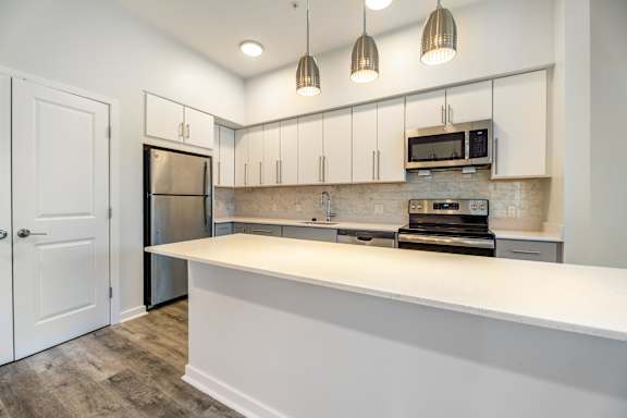 A kitchen with a white counter and a refrigerator.