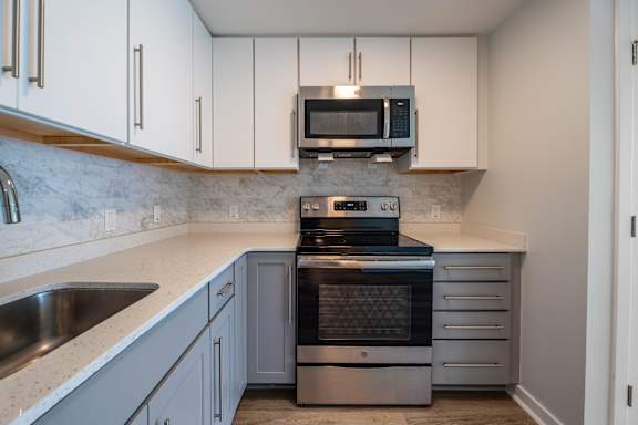 A kitchen with a stainless steel oven and microwave above it.