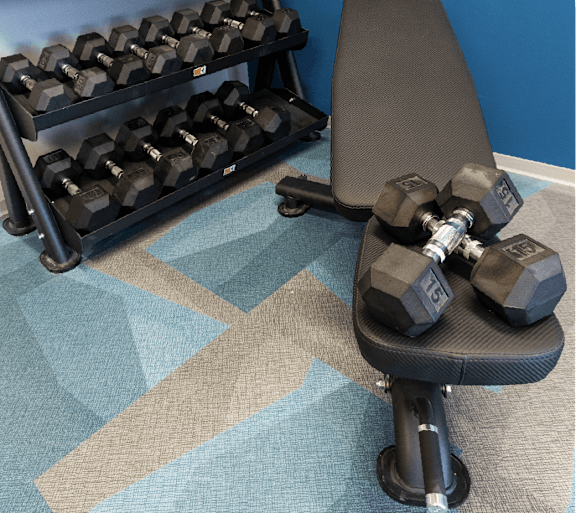 A black dumbbell is on a black bench. at 35 Broadway Apartments, Menands, 12204