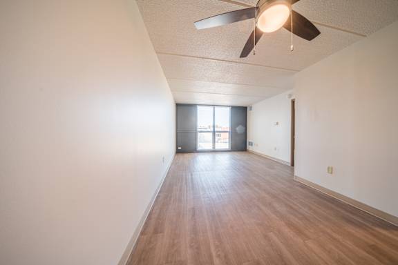 A room with a ceiling fan and wooden flooring at Highpoint Towers Apartments, Erie, PA