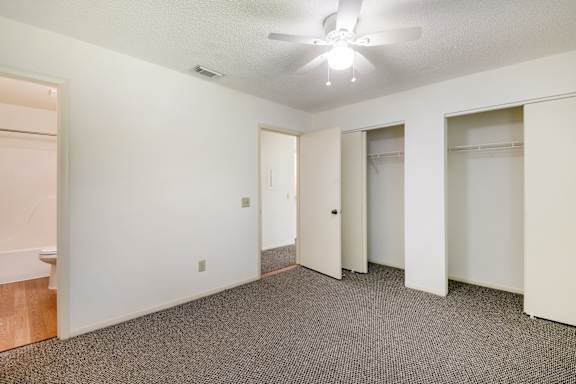 A room with a ceiling fan and carpeted floor at Fisherman's Landing Apartments, Ormond Beach, Florida