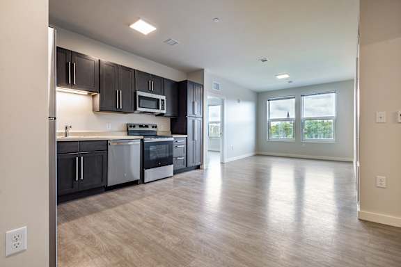 A kitchen with black cabinets and stainless steel appliances.