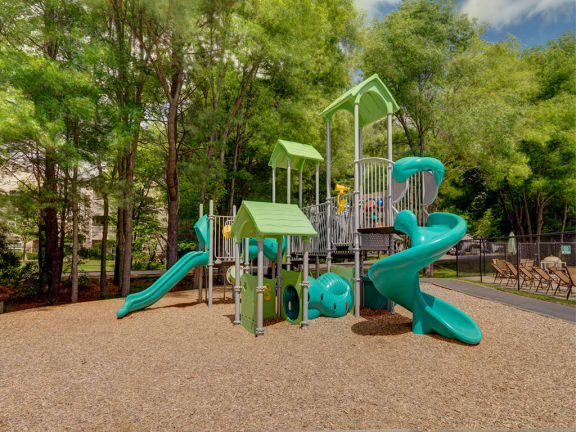 a playground with two slides and a picnic table in a park at Station Pointe, Mansfield, 02048