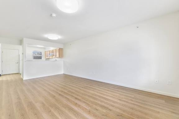 A room with wooden flooring and white walls at Creekwood Apartments, Watertown, 13601
