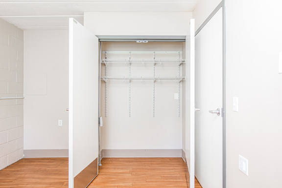 A white closet with a sliding door and shelves at Moorhead Tower Apartments, Pittsburgh, PA, 15213