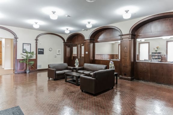 a resident clubhouse with leather couches and a coffee table at 13 State Street Apartments, New York