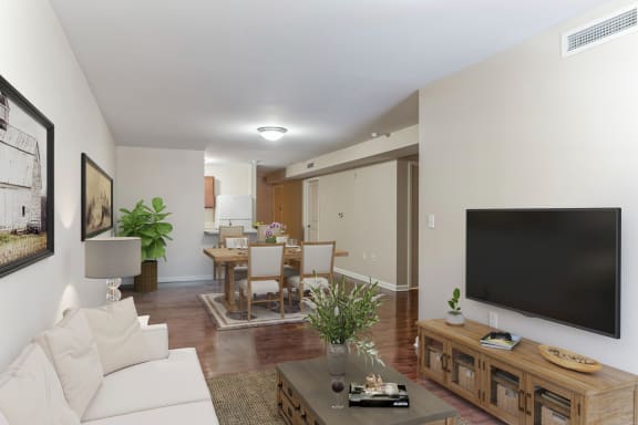 a living room with a large tv on the wall and a dining room table in the background at 13 State Street Apartments, New York