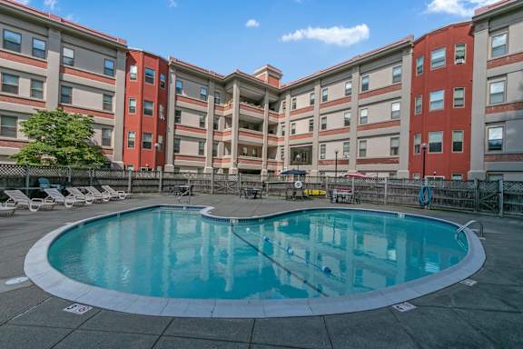 a swimming pool in front of an apartment building at Mill House Apartments, Greenfield, MA, 01301