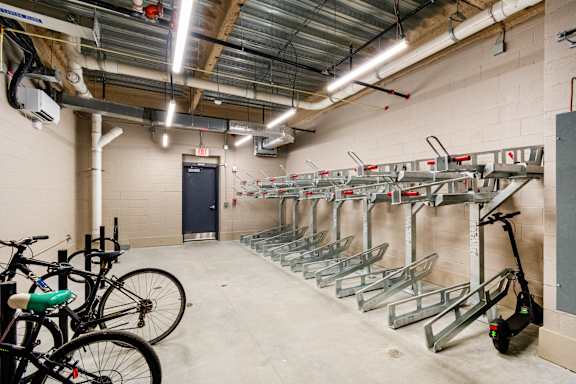 A bike rack with bikes and a scooter in a garage at Pok Oi Residences, Boston, MA, Massachusetts, 2111