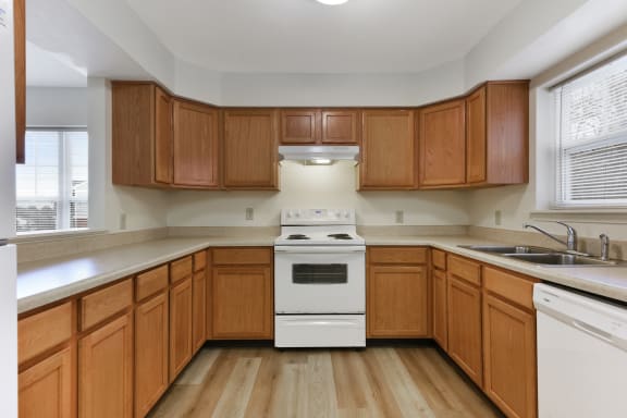 a kitchen with wooden cabinets and white appliances  at Summit Wood Apartments, Watertown, 13601