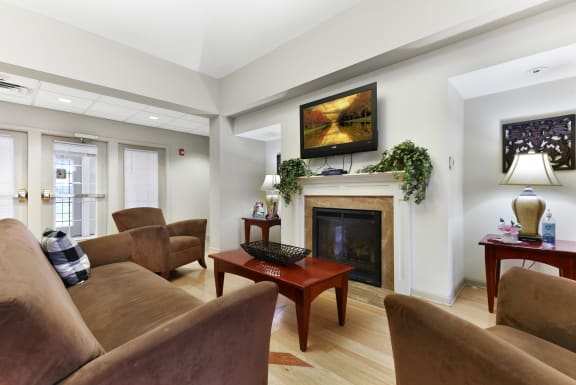 a living room with a fireplace and couches  at Summit Wood Apartments, Watertown, 13601