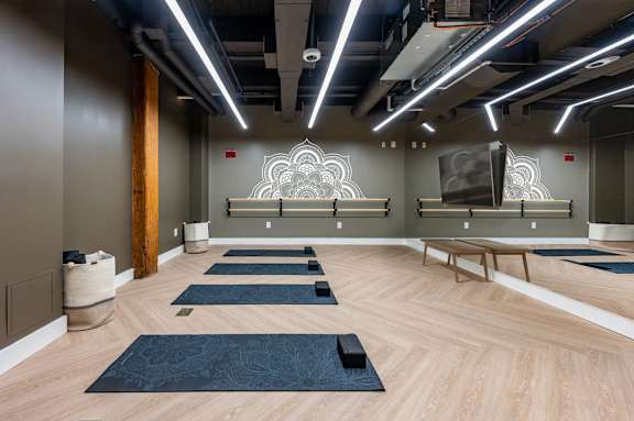 A yoga studio with wooden floors and mats at The Cordovan at Haverhill Station, Haverhill, Massachusetts
