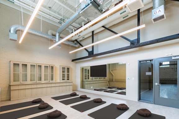 a yoga room with a large mirror and yoga mats on the floor at Beverly Village for Living & the Arts Apartments, Beverly, 01915