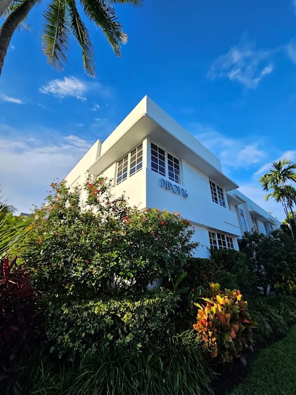 a tall white building with a blue sky in the background