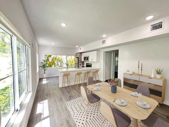 A modern dining room with a wooden table and chairs.