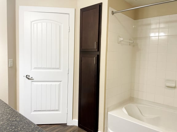 a bathroom with a white bathtub and a white door