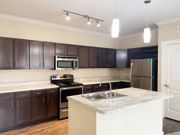 a kitchen with dark wood cabinets and white countertops