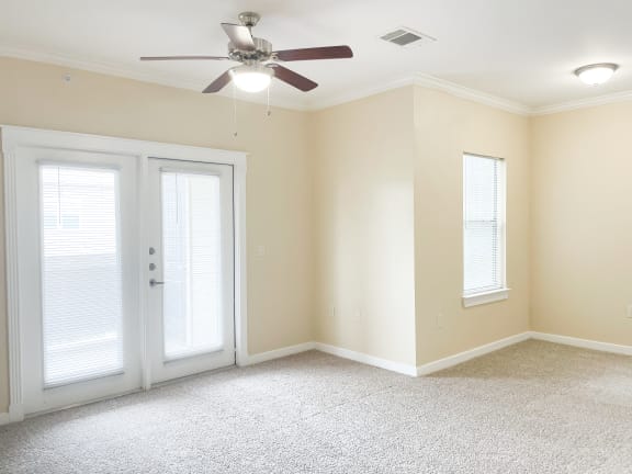 a bedroom with a ceiling fan and two windows