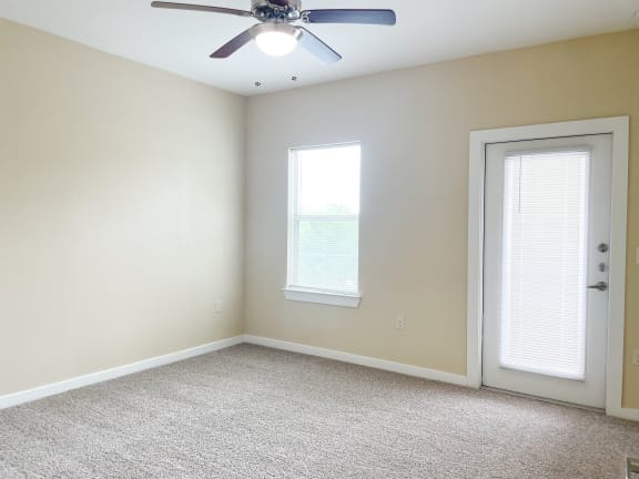 a bedroom with a ceiling fan and a door with a window