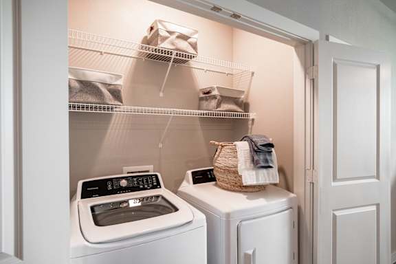 A small laundry room with a washer and dryer at 55 Fifty at Northwest Crossing, Houston, TX 77092