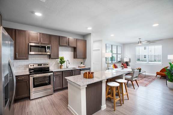 A modern kitchen with a large island and stainless steel appliances at 55 Fifty at Northwest Crossing, Houston, TX 77092