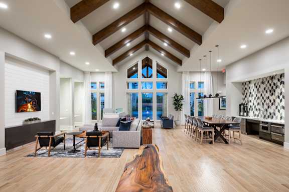 A modern living room with a large wooden floor and a high ceiling at 55 Fifty at Northwest Crossing, Houston, TX 77092