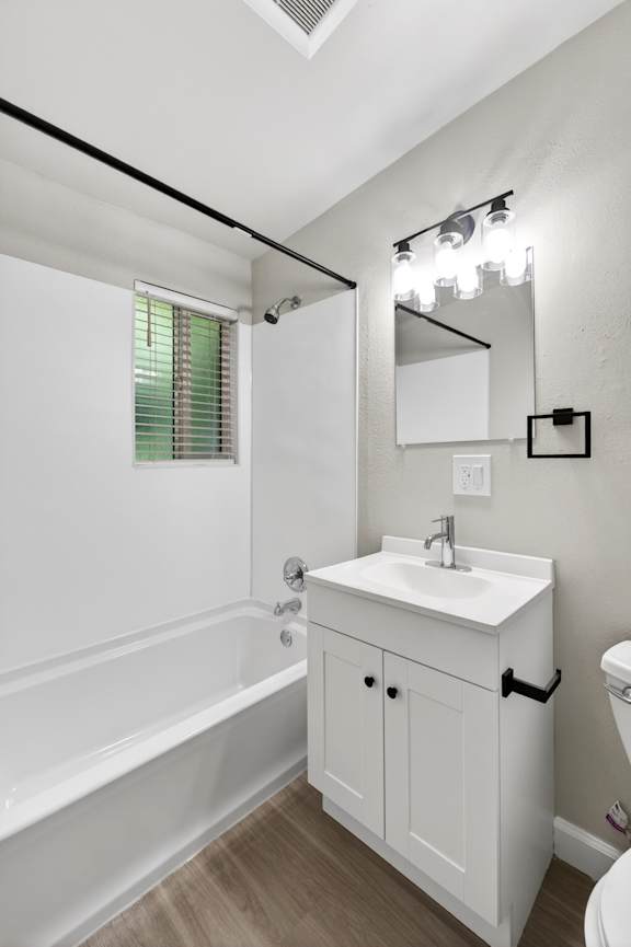 A white bathroom with a sink, toilet, and bathtub.