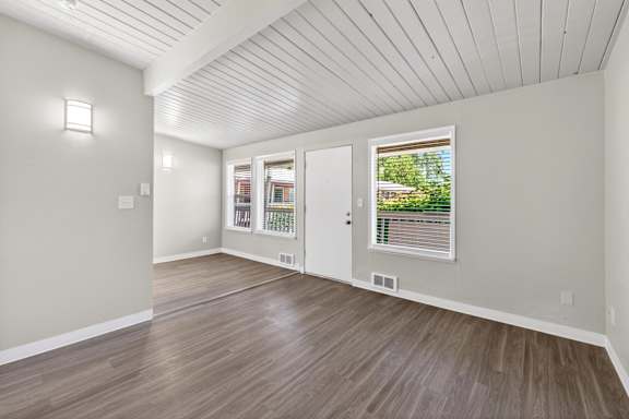 A room with a white ceiling and wooden flooring.