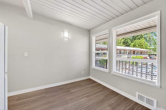 A room with a window showing a parking lot outside.
