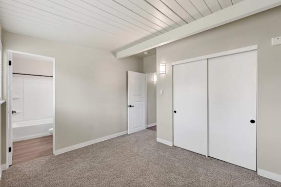A room with a white door, a white wardrobe and a white cupboard.