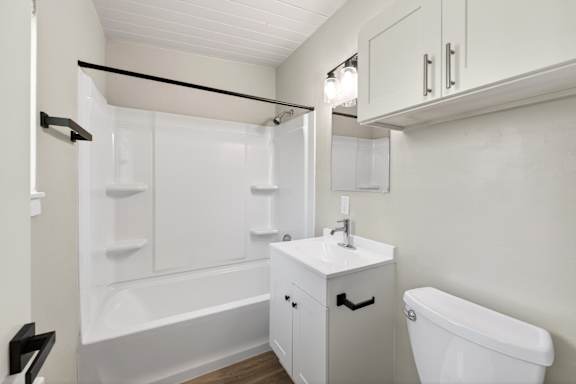 A white bathroom with a tub, sink, and toilet.