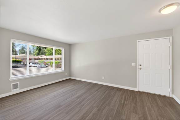 A room with a white door and a window with blinds.