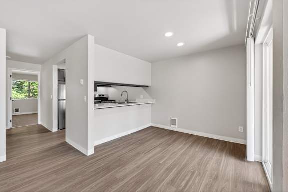 A kitchen with white cabinets and a wooden floor.