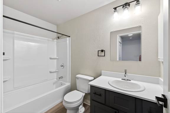 A white bathroom with a toilet, sink, and bathtub.