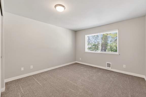 A room with a window and carpeted floor.