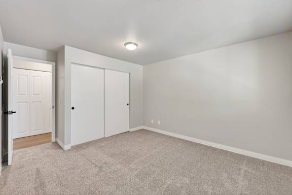 A room with a carpeted floor and a white door.