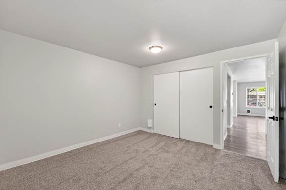 A room with a carpeted floor and a white door.