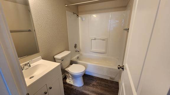 a bathroom with a toilet and a tub and a sink