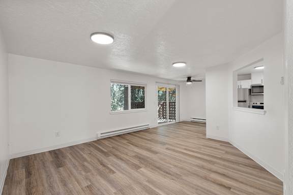A spacious room with wooden flooring and white walls.