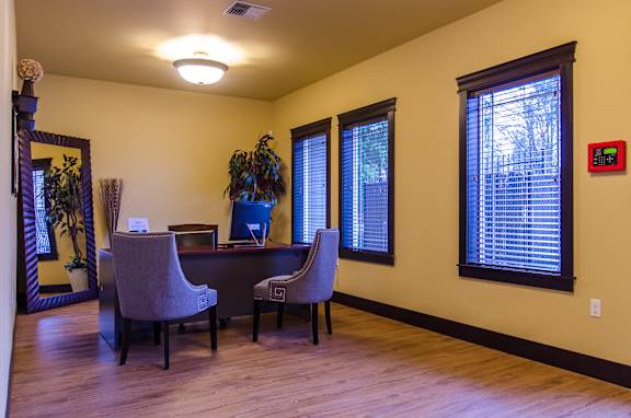A room with a desk and two chairs.