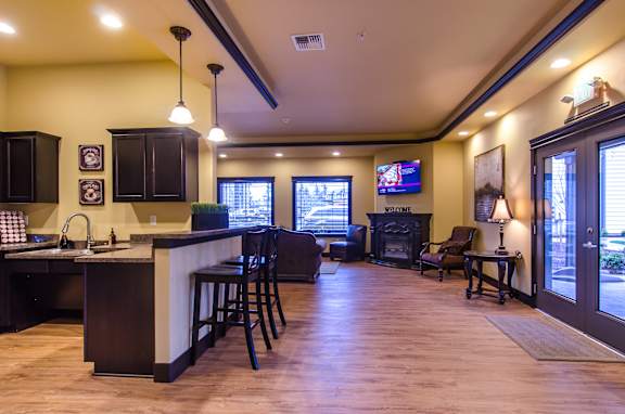 A modern kitchen with a bar area and a television.