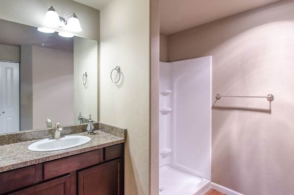 A bathroom with a sink, mirror, and towel rack.
