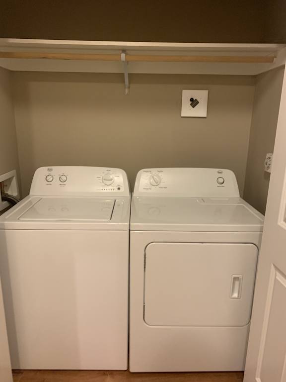 Two white front loading washing machines in a small laundry room.