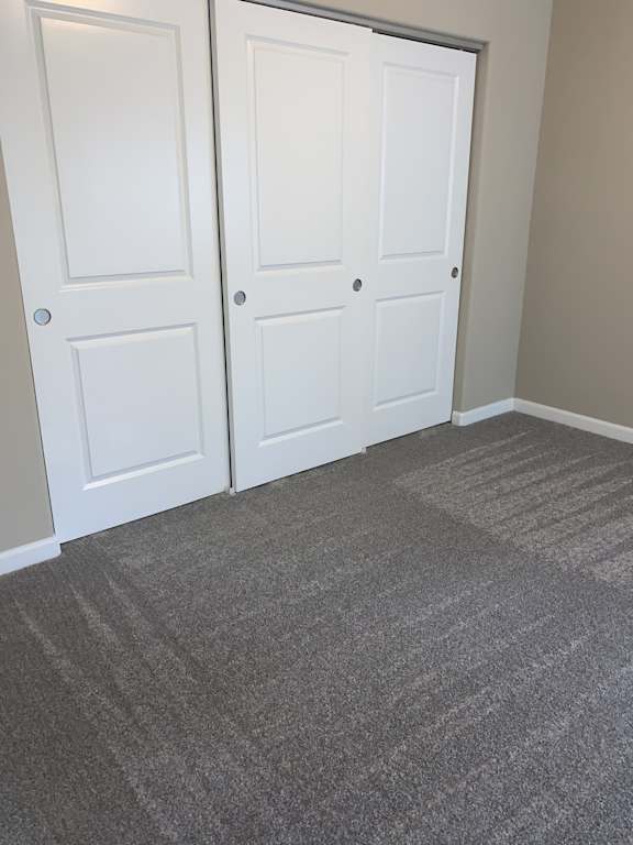 Two white doors with grey carpet in front.